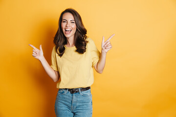 Image of joyful charming woman smiling and pointing fingers aside