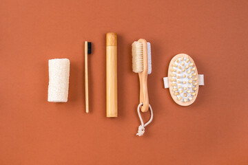 Set of bathroom accessories. Anti cellulite massager, bamboo toothbrush, loofah sponge, peeling brush on brown. Zero waste concept. Minimalistic style. Top view, creative layout.