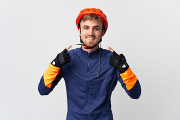 Fototapeta premium Young cyclist blonde man isolated on white background giving a thumbs up gesture