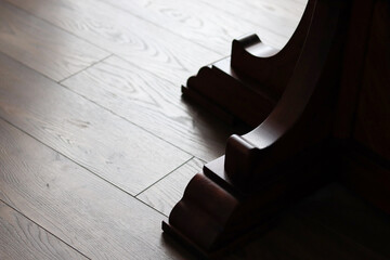 Wood carved tab. Carved oak underframe on a wooden floor. Dark wood.