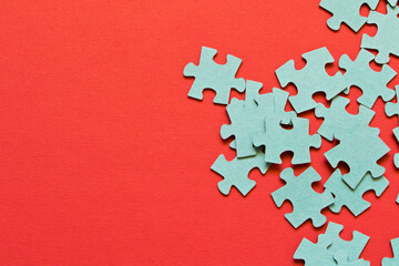 Puzzle. Many puzzle pieces on a red background. The concept of collective thinking.