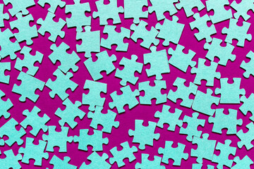 Puzzle. Many puzzle pieces on a purple background. The concept of collective thinking.