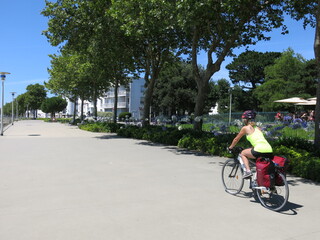 jeune femme cycliste à bicyclette avec sacoche pour randonnée à vélo sur piste cyclable le long...