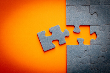 Puzzle. Many puzzle pieces on an orange background. The concept of collective thinking. - obrazy, fototapety, plakaty