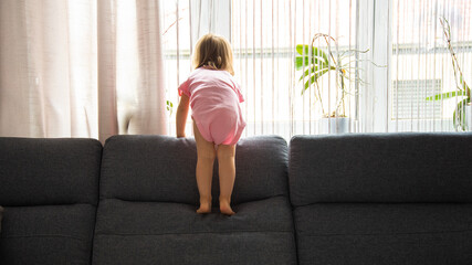 Fototapeta na wymiar Little baby girl on the sofa at home. copy space