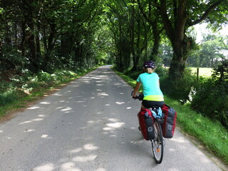 jeune femme cycliste à bicyclette avec sacoche pour randonnée à vélo sur piste cyclable le long de la Loire et en Bretagne