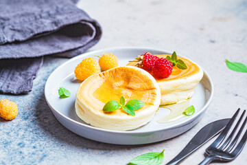 Japanese fluffy pancakes with raspberries in gray plate, gray background. Japanese cuisine concept.