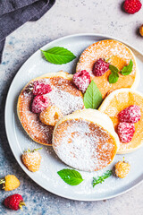 Japanese fluffy pancakes with raspberries in gray plate, gray background, top view. Japanese cuisine concept.