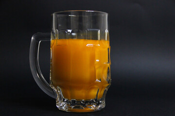 Full glass of orange juice on a black background