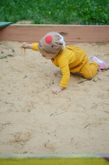 Photo of a toddler girl playing with sand