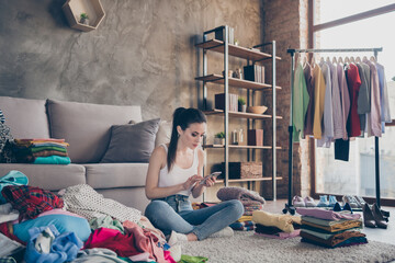 Portrait of her she nice attractive pretty focused girl sitting on floor messy room selling things...