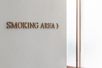 The directions text  "Smoking Area" on the gray wall.