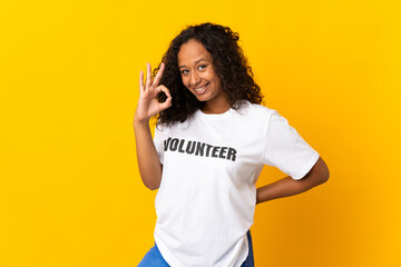 Teenager cuban volunteer girl isolated on yellow background showing ok sign with fingers