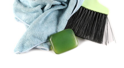 Green dustpan bristle, broom sweeper with microfiber cloth and glycerine soap bar isolated on white...