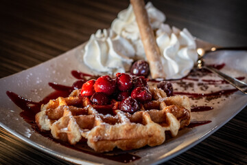 Waffle dessert with cherries and whipped cream