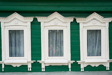 Old wooden houses with beautiful windows.Frames with tiles.An old Russian house.