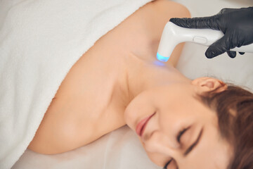 Beautician caring about skin on neck of client