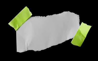 White wrinkly paper scrap with green sticky tape isolated on black background and texture, top view