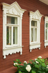Old wooden houses with beautiful windows.Frames with tiles.An old Russian house.