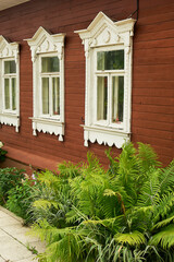 Old wooden houses with beautiful windows.Frames with tiles.An old Russian house.