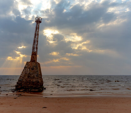Old lighthouse Kurmrags on the sandy shore of the Baltic in spring. Three-frame panorama. Latvija
