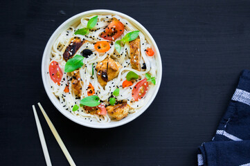 Homemade udon with grilled turkey breast, tomatoes, red hot chili pepper, basil and black and white...