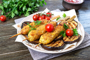Lula kebab with grilled eggplant on pita bread. Dietary chicken kebabs on a skewer with vegetables.