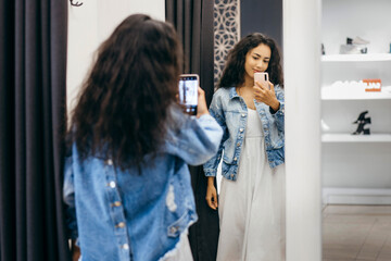 Shopper woman trying clothing dress  in clothes store during sale.