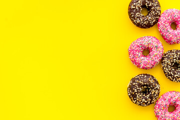 Donuts flat lay pattern on yellow background, top view