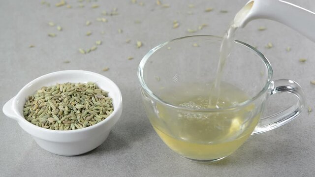 Fennel tea in a glass cup with fennel seeds in a bowl