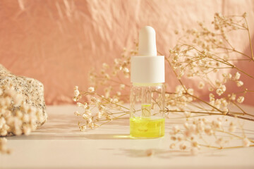 Obraz na płótnie Canvas Bottles of essential cosmetic oil in a glass bottle on a white table with a natural background. Aromatherapy oil, the concept of natural cosmetics. Space for text.