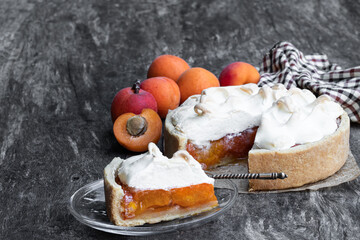 Tasty meringue pie with fresh apricot on wooden table