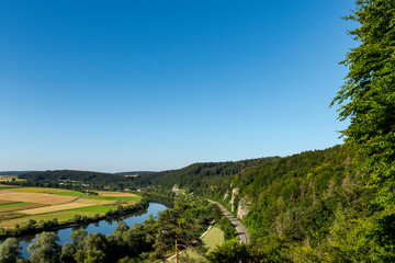 Fototapeta na wymiar Scenic view over the village Lohstadt and the river danube near Regensburg, Bavaria, Germany with single train track on sunny summer day with clear sky