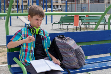 A portrait of a disgruntled, unhappy boy who is forced to study. Boy shows dislike gesture....