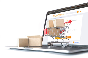 Paper cartons or parcel in the cart on laptop keyboard. Shopping service on online web and offers...