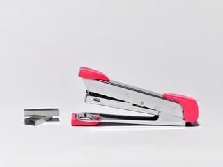 Pink stapler and staples isolated on white background. Office work equipment concept