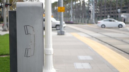 Retro coin-operated payphone station for emergency call on street, California USA. Public analog pay phone booth. Outdated technology for connection and telecommunication service. Cell handset on box