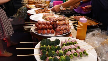 Traditional Asian night street food market in Thailand. Barbecue meatballs and other exotic delicious snacks for sail. Ready to eat food