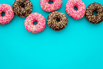 Colorful donuts pink and chocolate icing. Flat lay of bakery, above view