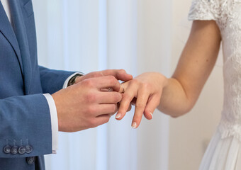 Fototapeta na wymiar Groom putting the ring to brides finger
