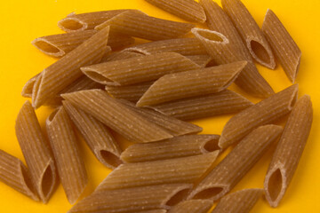 Pasta from hard wheat. Italian pasta on yellow background,  place for text.