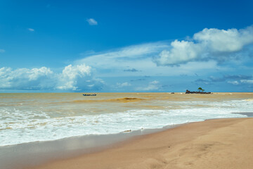 Africa's gold coast with colored yellow sea and fishing people on their way out to sea in Axim Ghana West Africa
