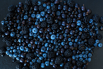 Mix set layout of different types of black berries on a black table. Stylish seasonal vitamins