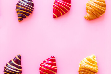 Frame of croissants - fresh bakery on pink background. Top view