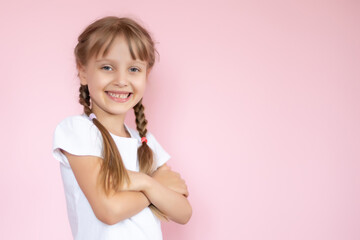 Beautiful little blonde girl with long hair in white T-shirt smiling on a pink background