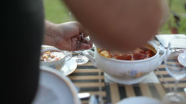 Delicious meat soup is placed from a pan on a plate. Bograch. Borsch.