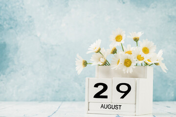 White cube calendar for august decorated with daisy flowers