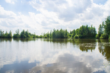 Fototapeta na wymiar Summer lake shore with sky reflection