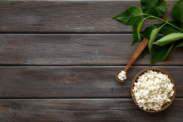 Cottage cheese in bowl with spoon - for breakfast - top view copy space
