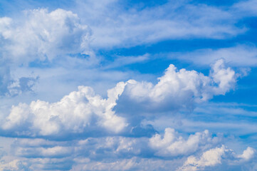 Naklejka na ściany i meble White bright contrasting clouds on blue sky